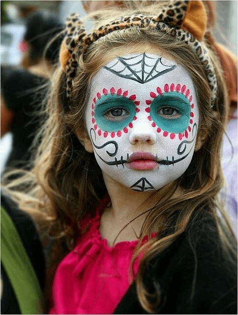 Child with Día de los Muertos sugar skull face paint